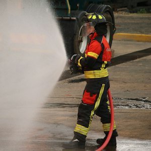 Firefighter using water hose - Fire Warden