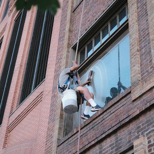 Worker in safety harness cleaning building - Safety Harness